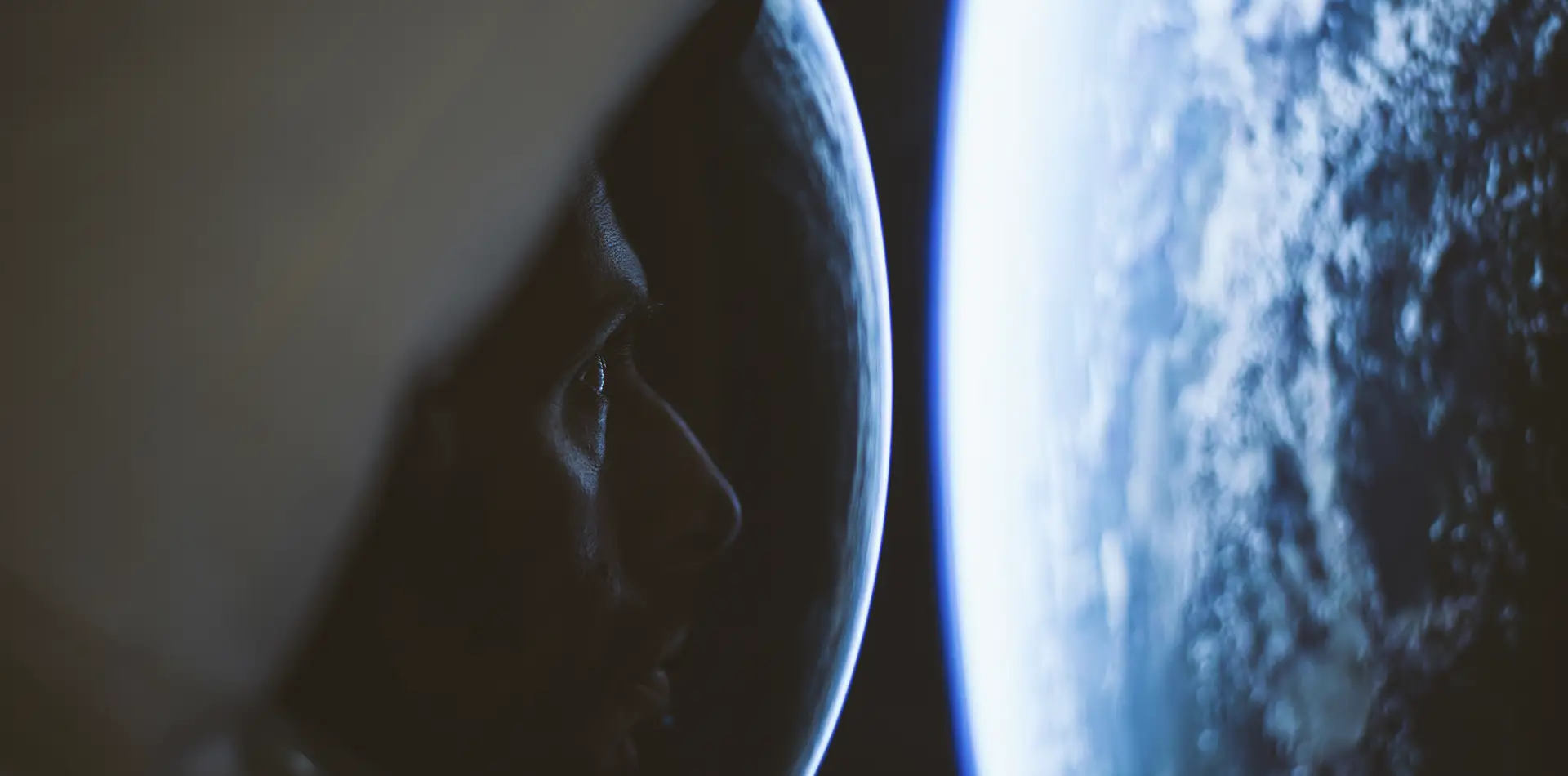 silhouette standing between Earth and a distant planet