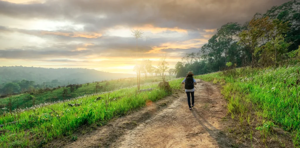 Person walking a peaceful path at sunrise, symbolizing the journey of spirituality