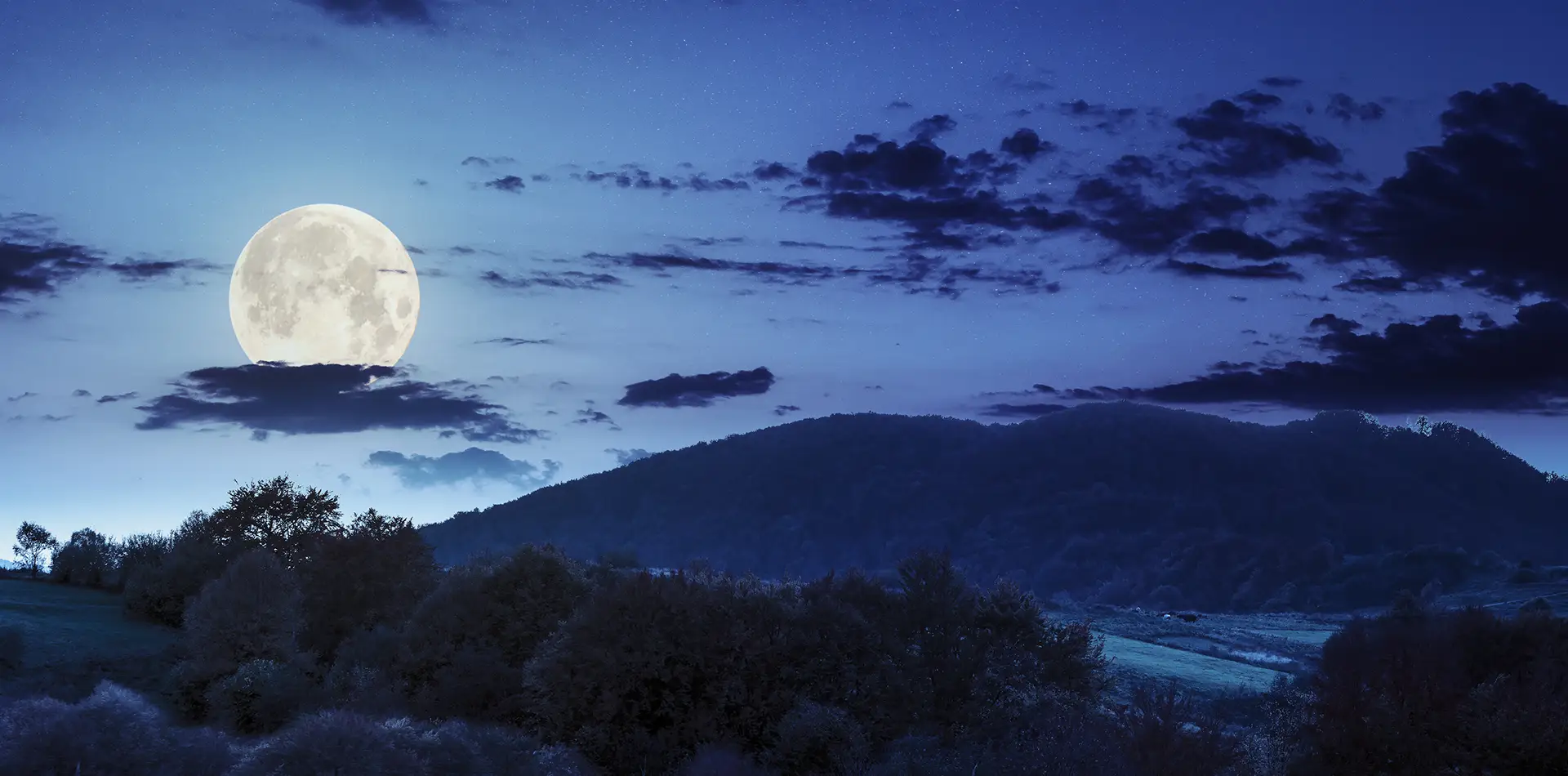 A wide panoramic view of a large, luminous full moon reflecting over a calm ocean, symbolizing the connection between lunar cycles and the human psyche.