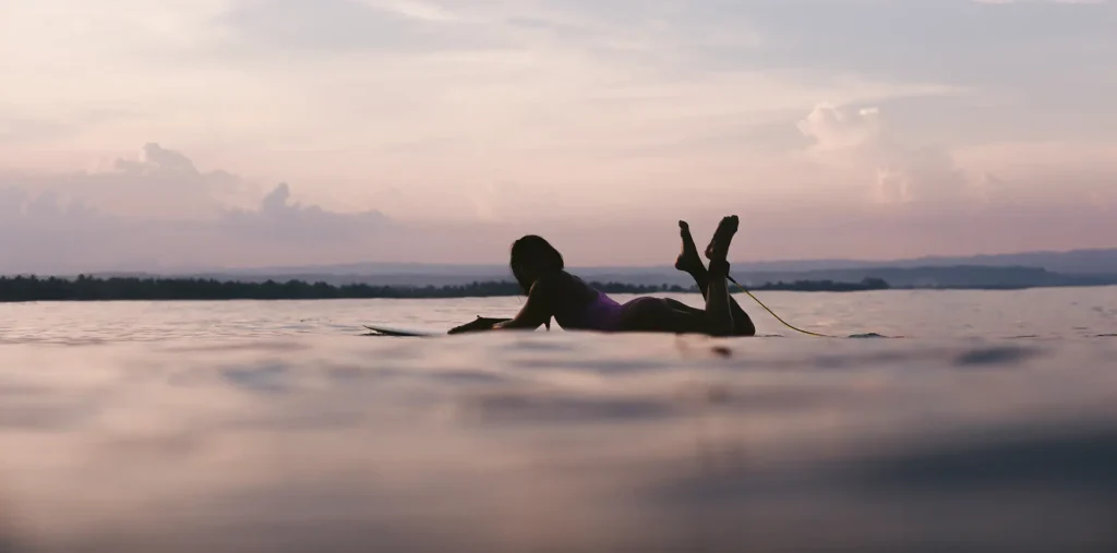 A person floats peacefully in still, clear water, eyes closed in a state of total surrender and mental quietude.