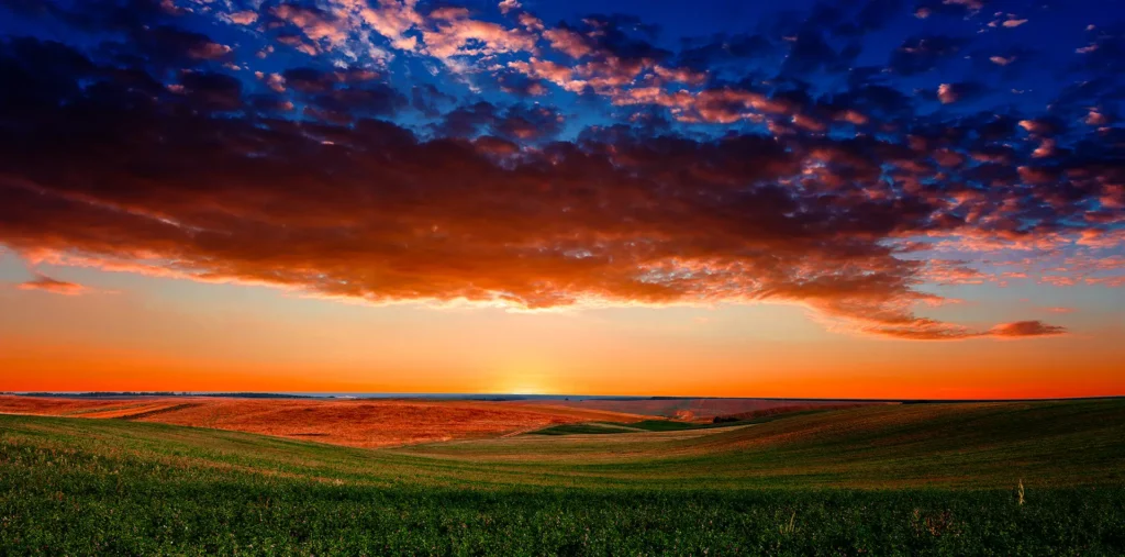 Colorful sunrise over a vast landscape, symbolizing the living experience of Beauty as energy