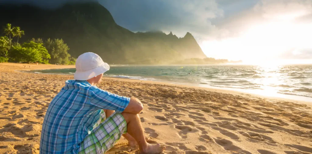A person sitting alone on a peaceful beach at sunset, contemplating the horizon