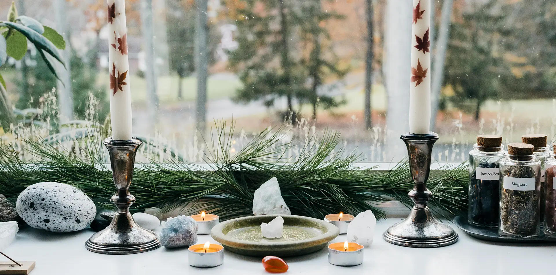 A peaceful home altar with candles, gemstones, and meaningful spiritual objects on a cloth-covered table