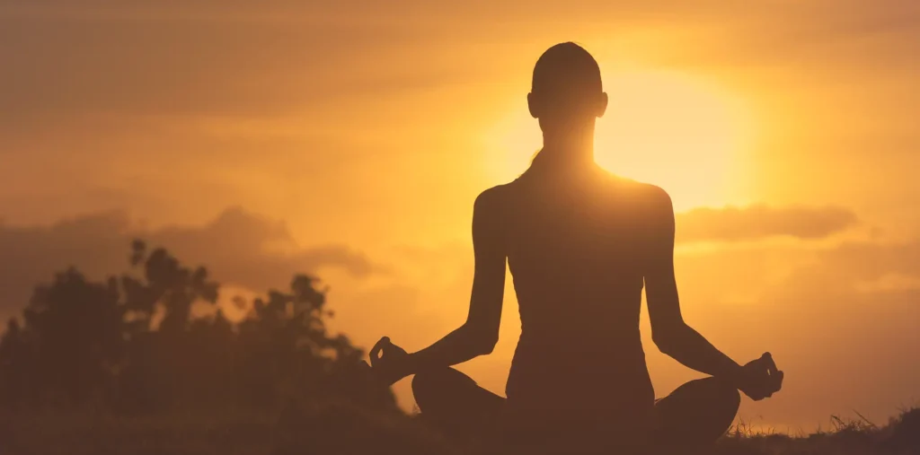 A person surrounded by warm golden light representing emotional energy, love, and peace of mind
