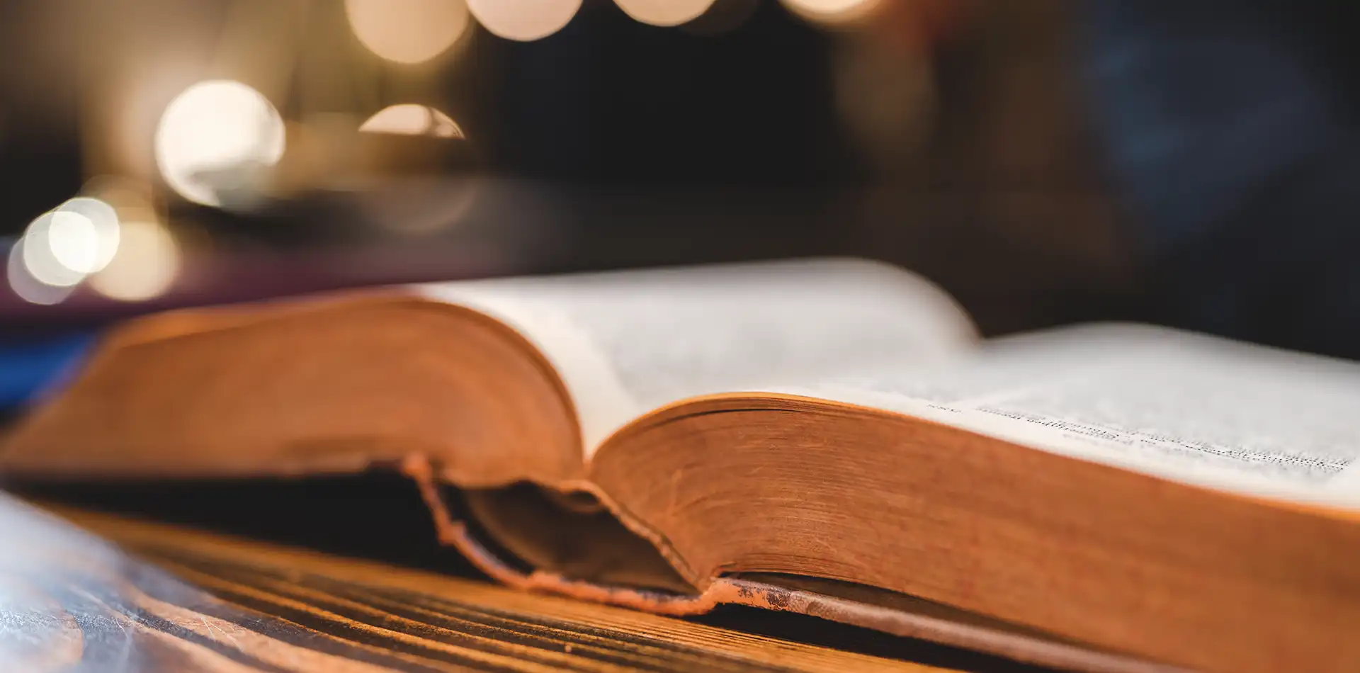 Open ancient scripture with golden light rays, representing faith, spiritual teachings, and conscious awareness