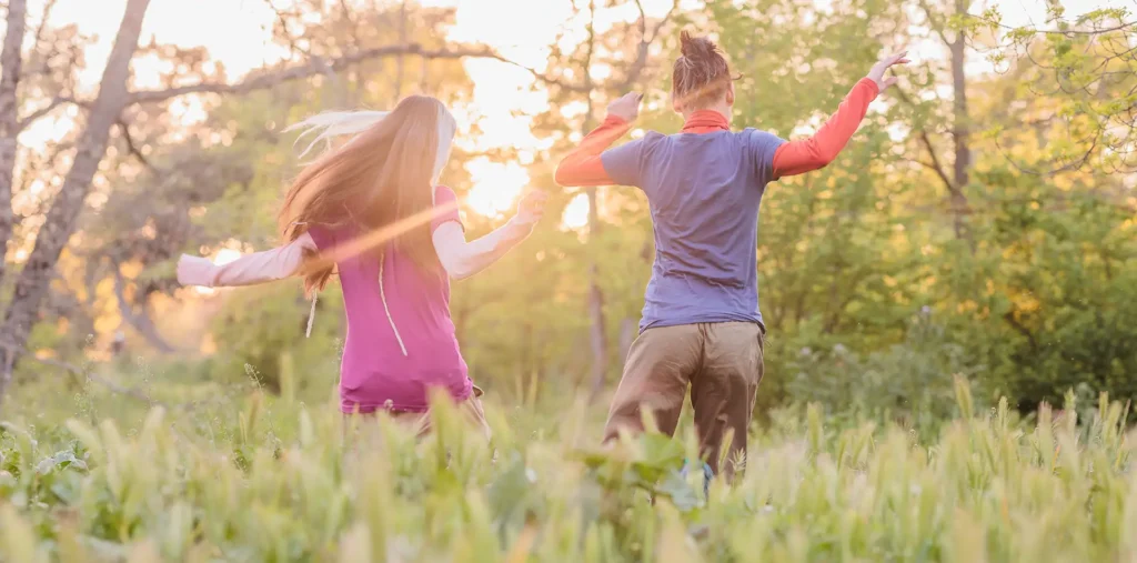 Happy children playing outdoors in a sunlit garden surrounded by nature