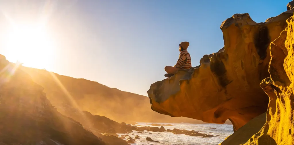 A person meditating in peaceful stillness surrounded by golden cosmic light, representing spiritual consciousness and inner energy