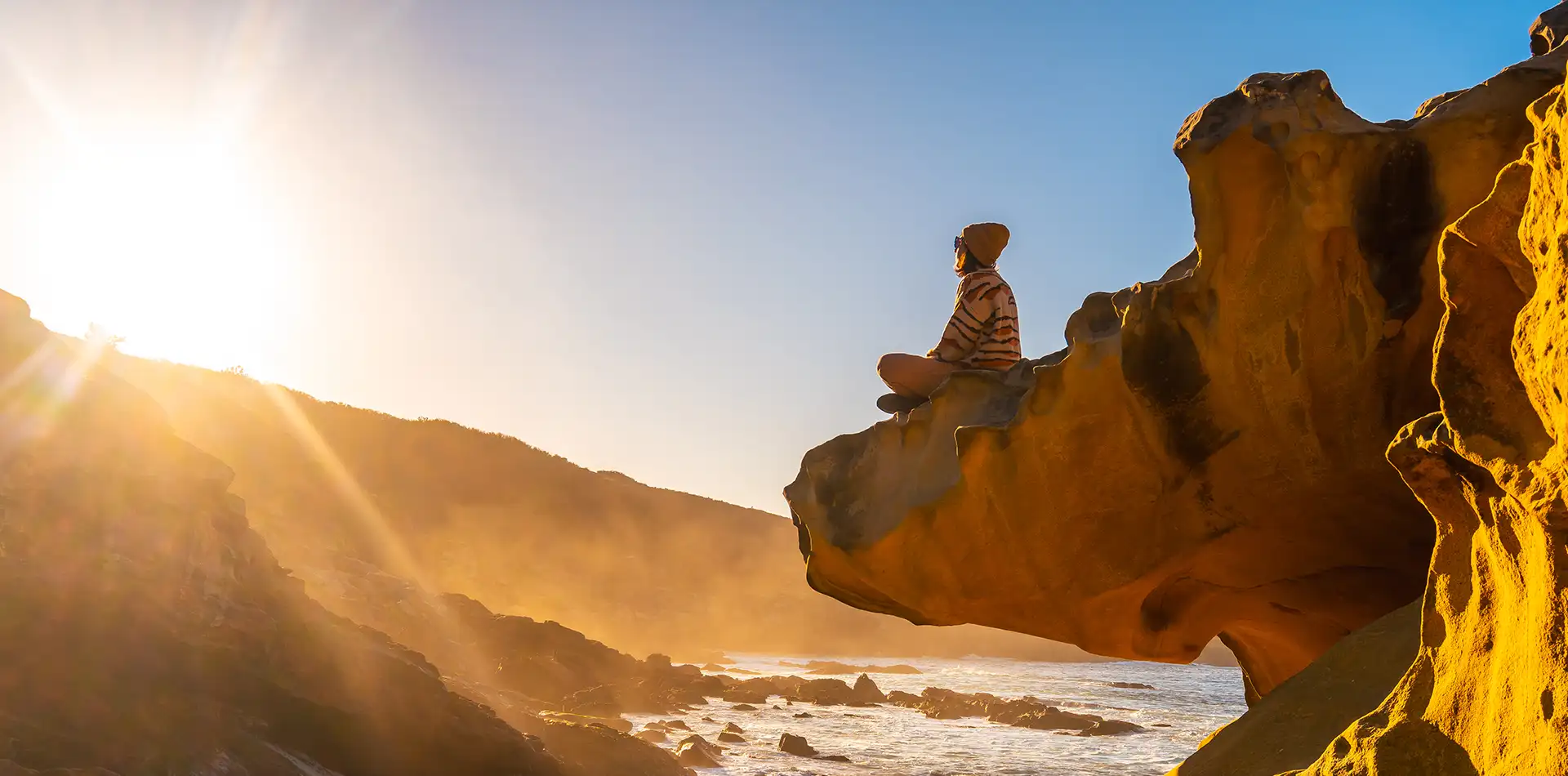 A person meditating in peaceful stillness surrounded by golden cosmic light, representing spiritual consciousness and inner energy