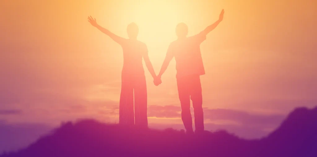Two silhouettes merging into a single light, representing the spiritual journey from duality to oneness