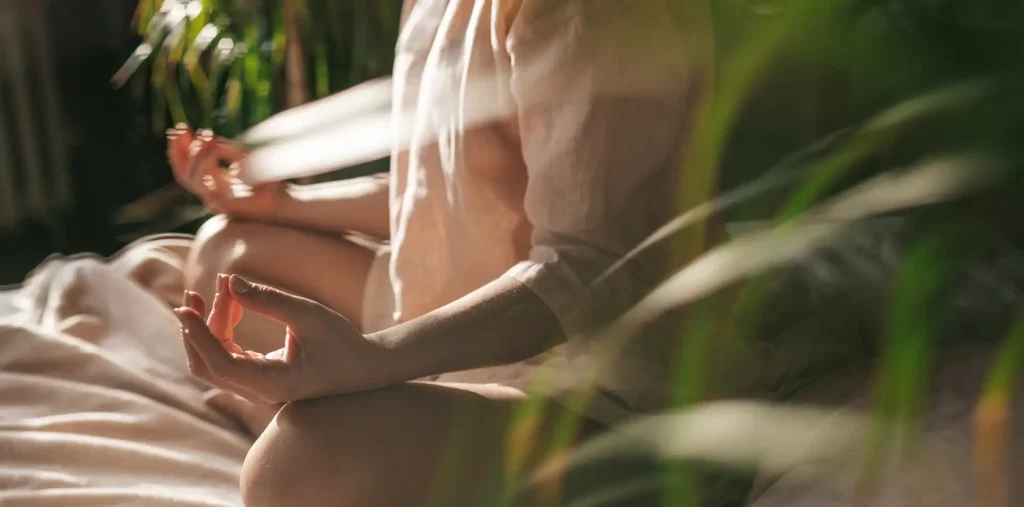 A person sitting calmly with eyes closed, practicing how to be present through quiet breath and awareness
