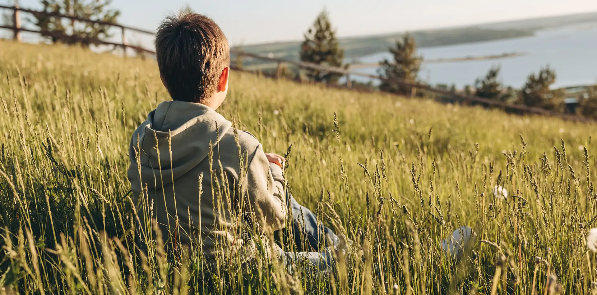 A child sitting peacefully in an open field, symbolizing the spiritual journey of reconnecting with the inner child