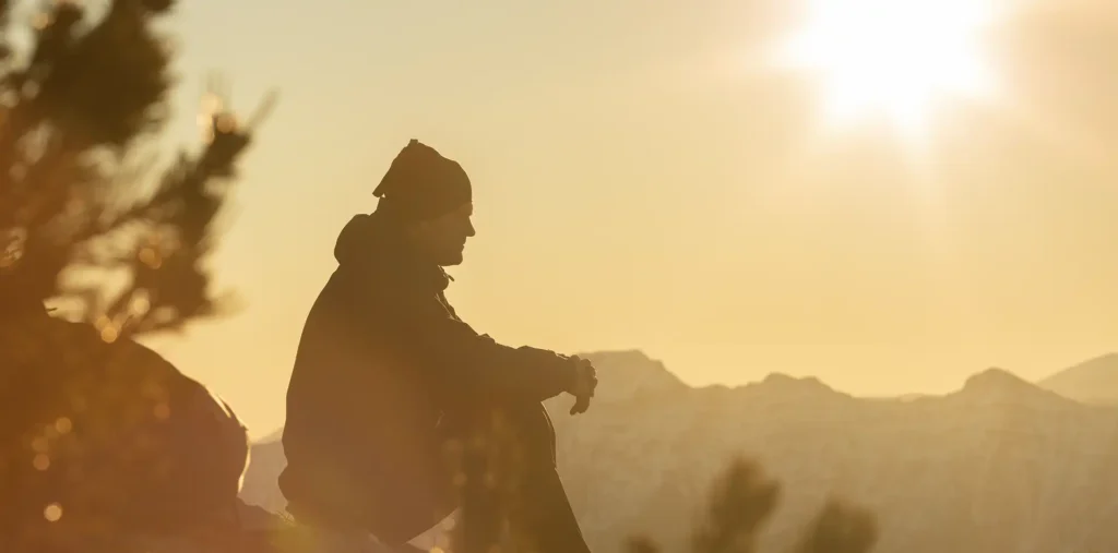 Person sitting peacefully in nature, reflecting on life and what is truly worthwhile