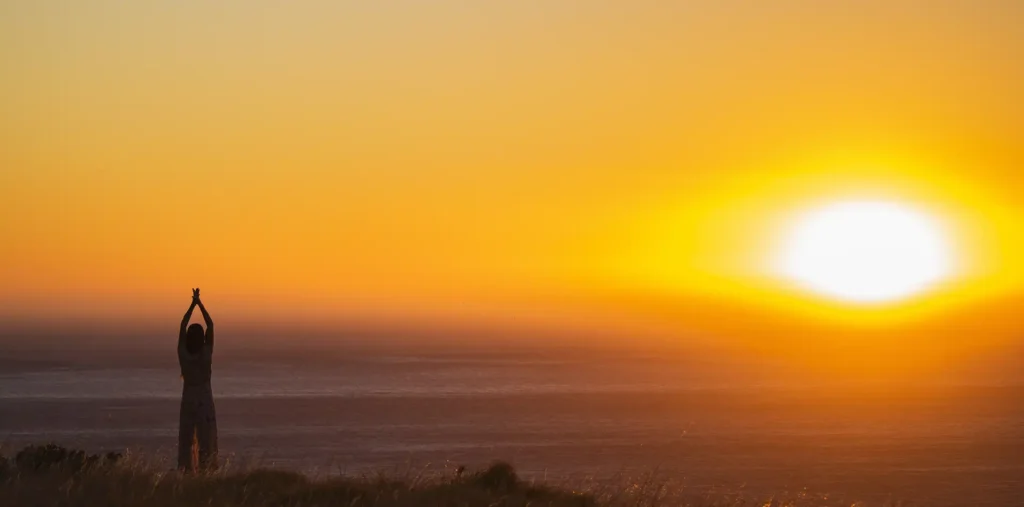 A figure bathed in warm golden light at dawn, symbolizing the inner glory that lives within all of us