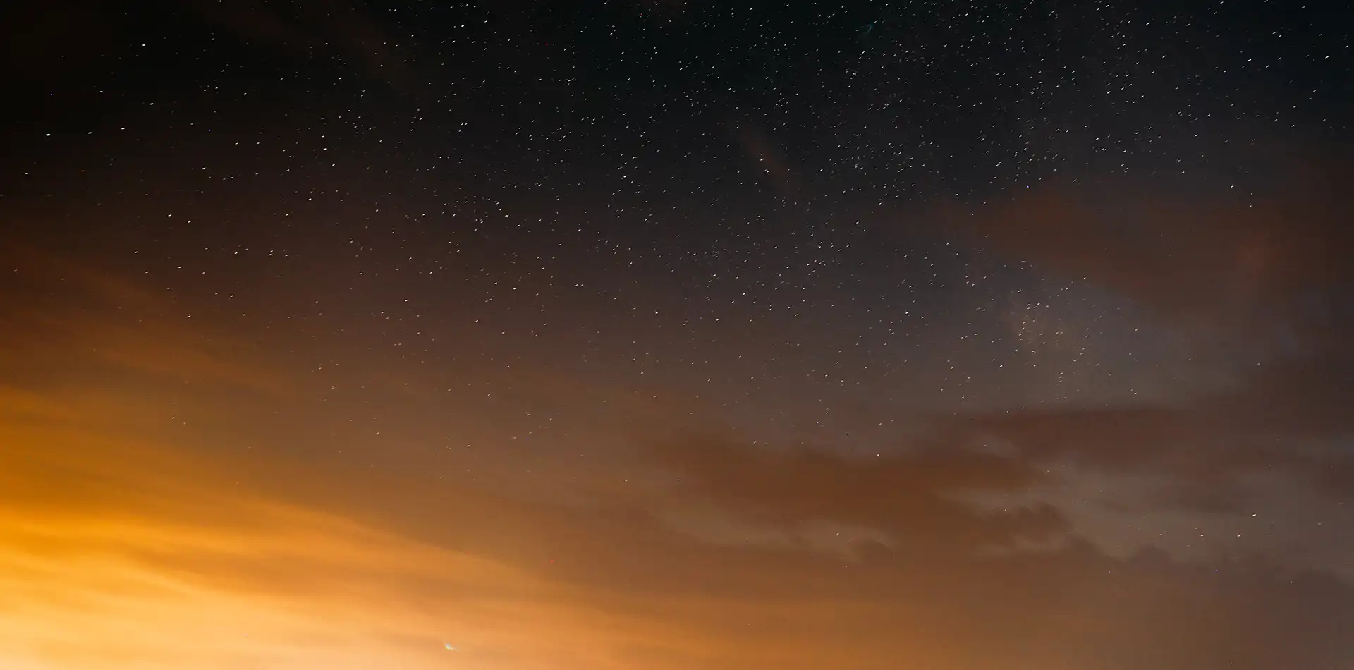 A single bright star radiating golden light above a calm horizon, symbolizing energy and consciousness