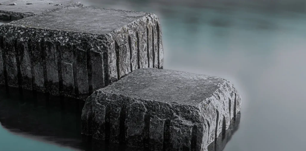 A single smooth stone resting on calm water, representing simplicity, balance, and inner peace