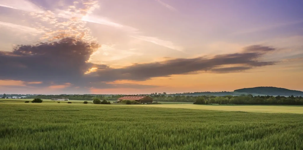 Soft rays of light breaking through dark clouds to reveal a clear landscape below
