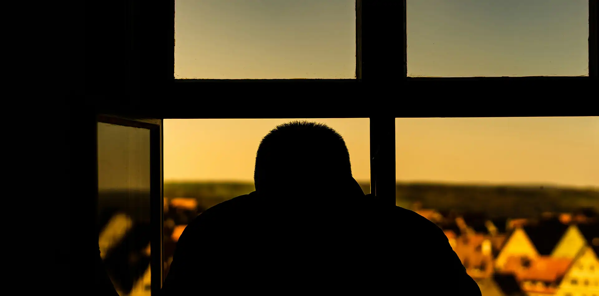 Older person sitting calmly in soft morning light, resting in quiet reflection