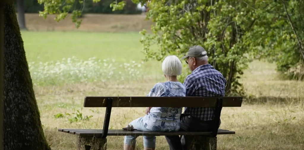 Older couple sitting together in a quiet sunlit living room in a calm, reflective moment