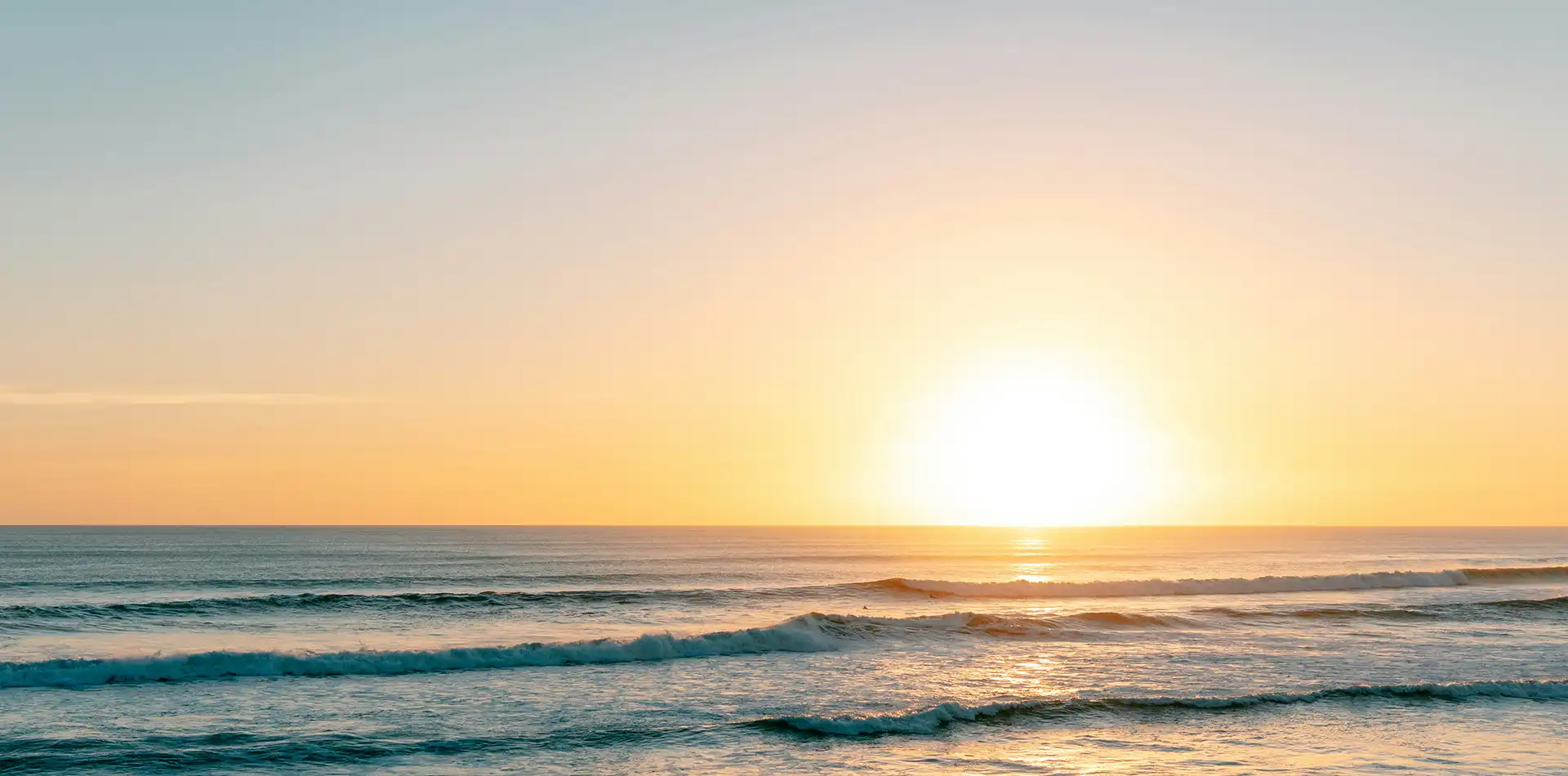 Gentle ocean wave meeting the shore at sunrise, reflecting what is peace, oneness, and harmony with nature