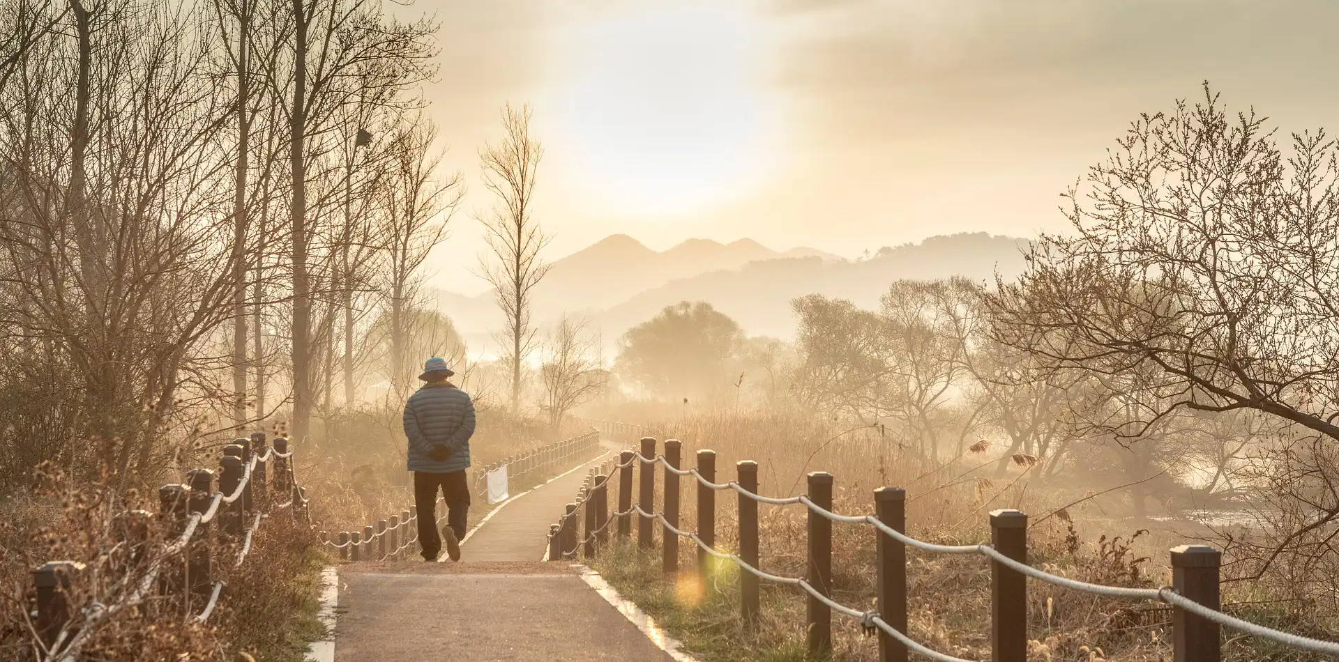 Traveler walking a winding path at sunrise, illustrating the poem by James McCrae on life as a journey