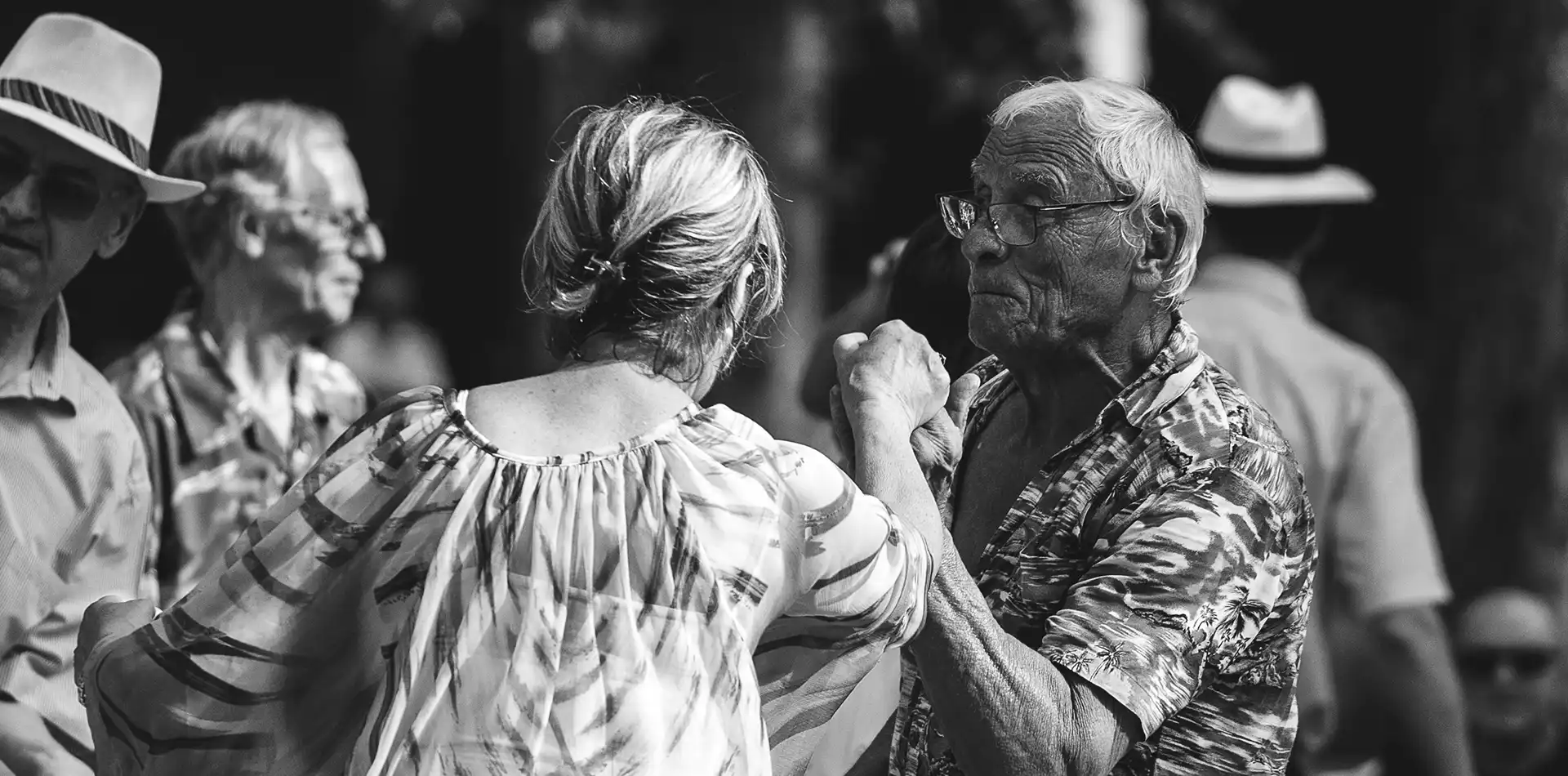 Diverse group of older adults singing and dancing together at a spirituality group gathering, sharing love and peace